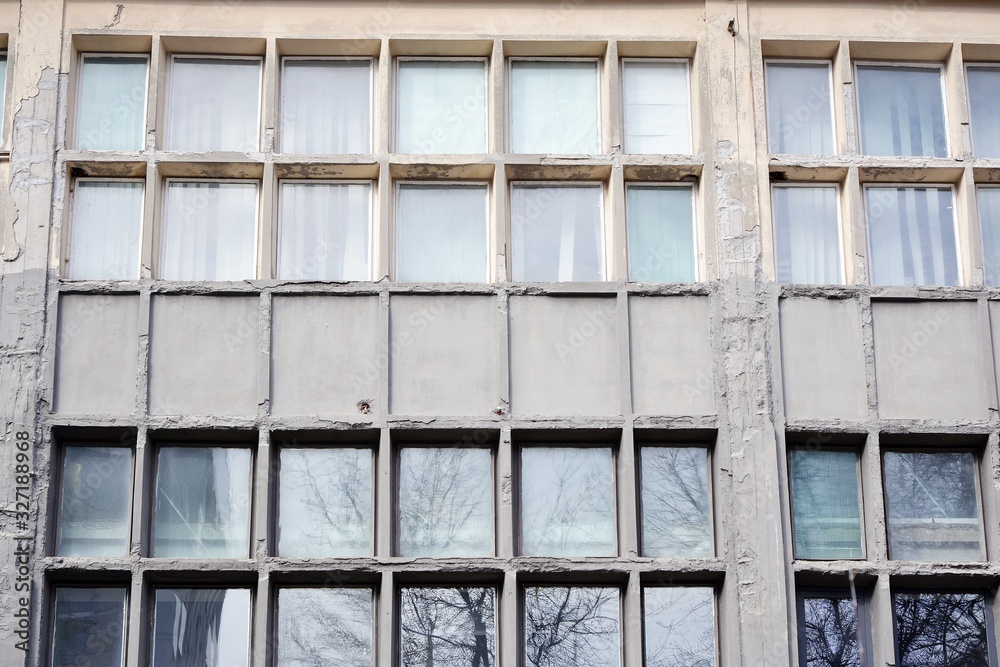 Facade of an old industrial office building with a predominance of old cement and old structural ele