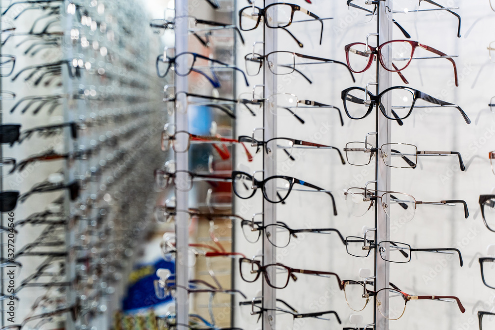 Showcase with glasses in optics. Modern designed eyeglasses rims in a row