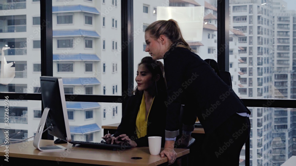 Young leader gives advice to young woman worker in modern office. Leadership and training concept.