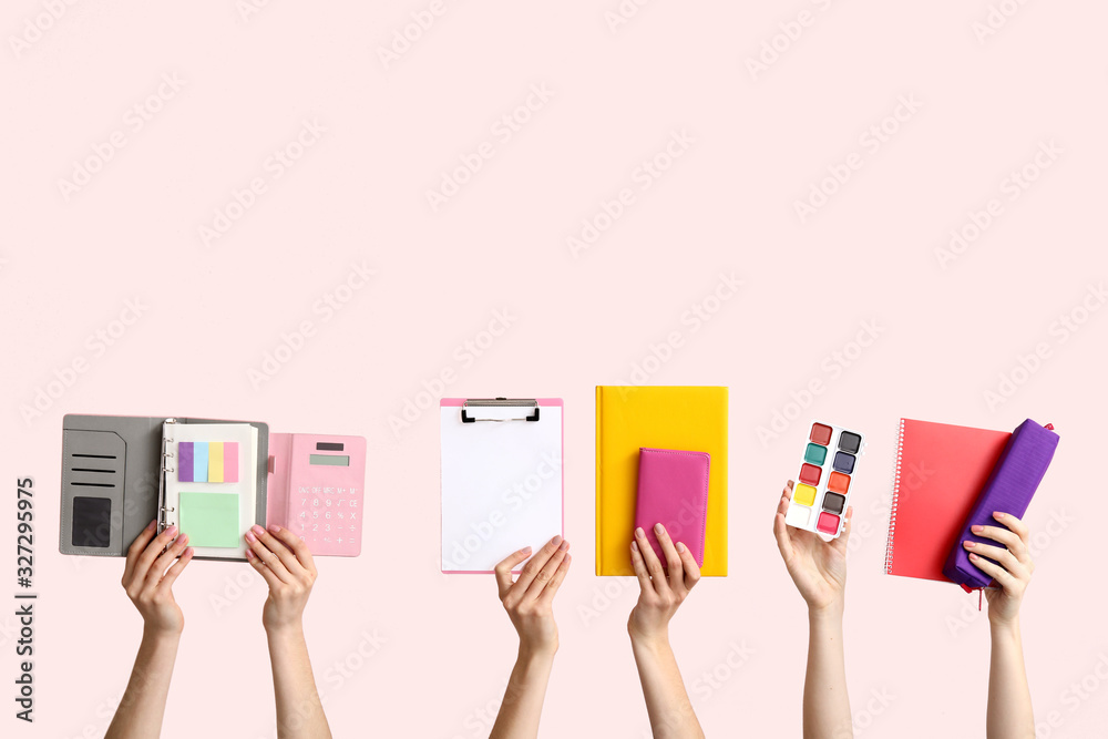 Many hands with school supplies on light background