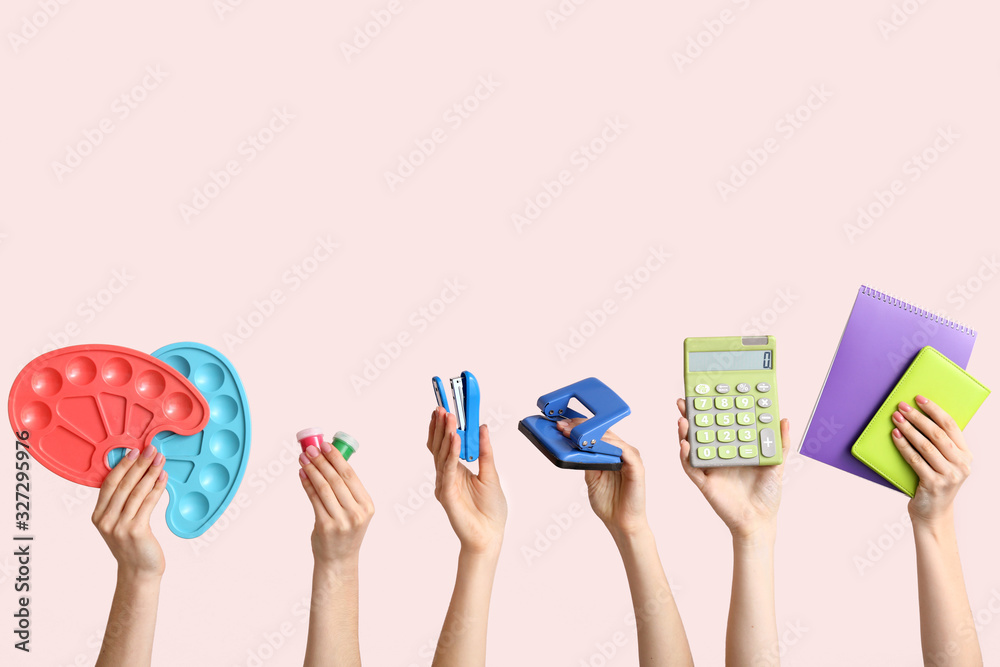 Many hands with school supplies on light background