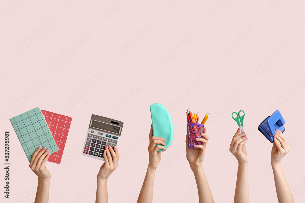 Many hands with school supplies on light background