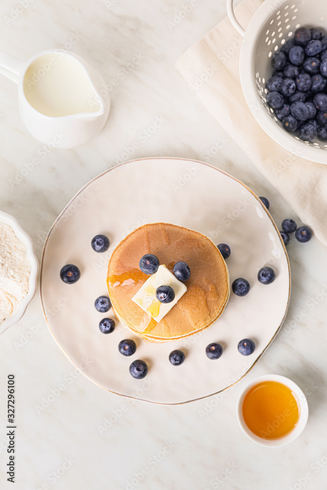 Tasty pancakes with honey, butter and berries on table