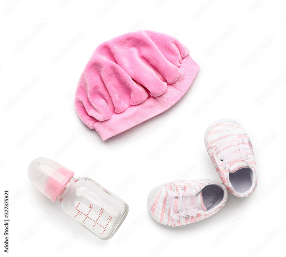 Baby hat with booties and bottle on white background