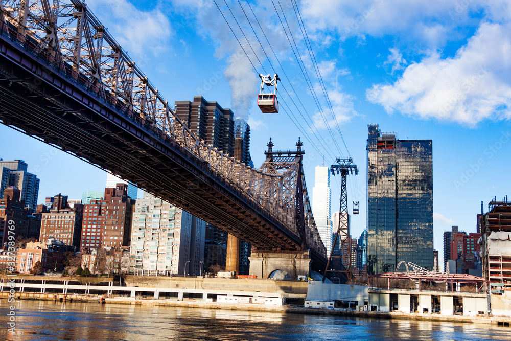 East river with Roosevelt Island tramway system and Ed Koch Queensboro Bridge over New York building