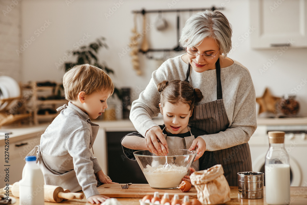 happy family grandmother and grandchildren cook in the kitchen, knead dough, bake cookies.