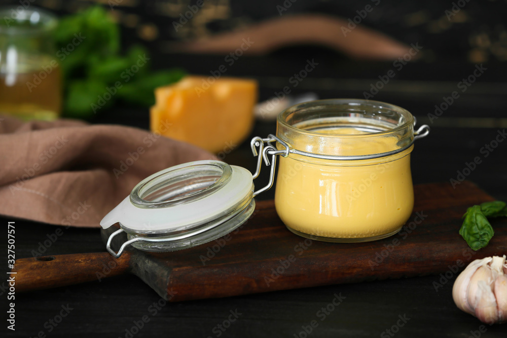 Jar of tasty sauce on dark table