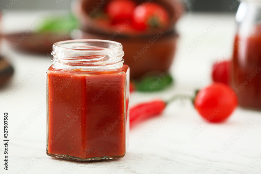 Jar of tomato sauce on white table