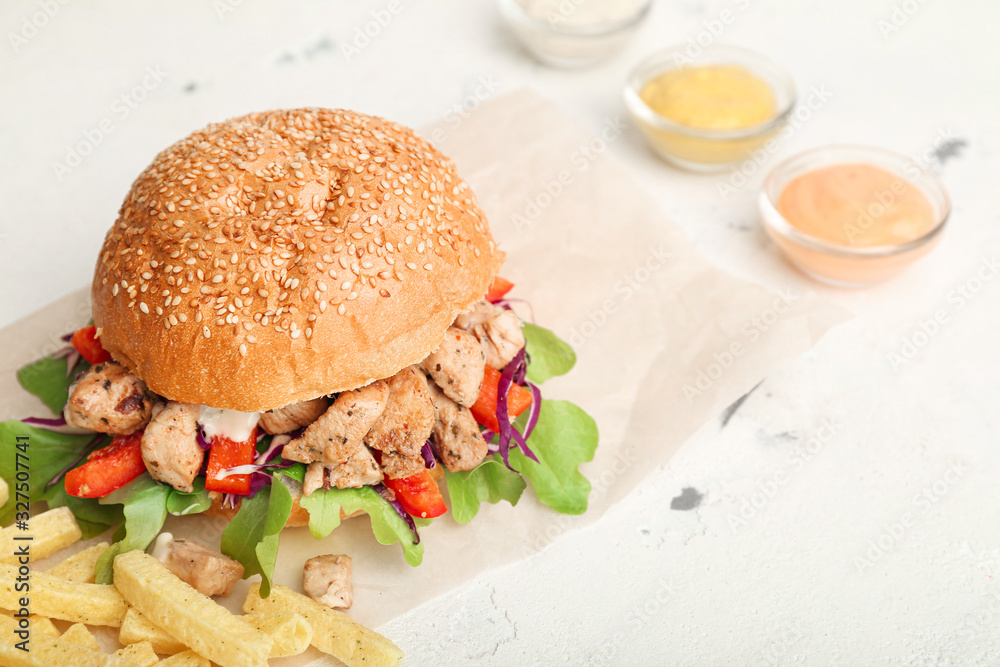 Tasty doner kebab in bun and french fries on white background