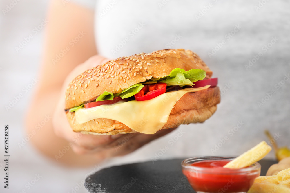 Woman with tasty doner kebab in bun, french fries and sauce, closeup