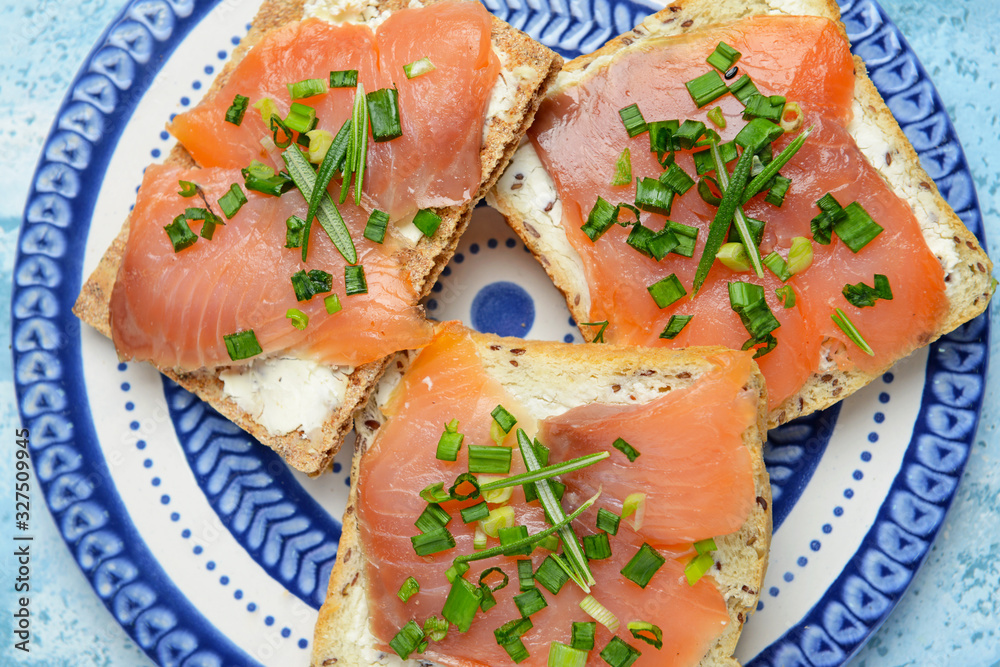 Sandwiches with tasty cream cheese and salmon on plate