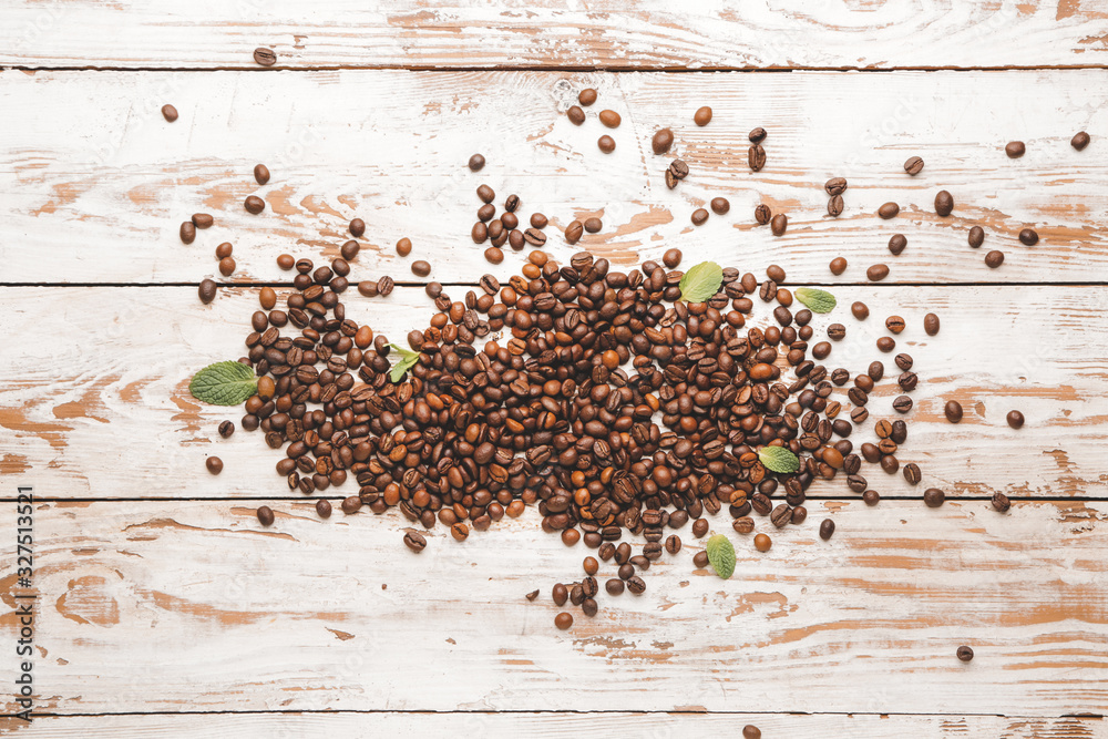 Many coffee beans on wooden background