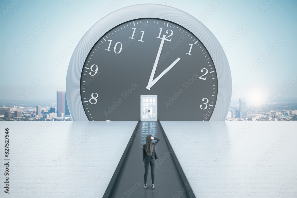 Businesswoman looking on big clock