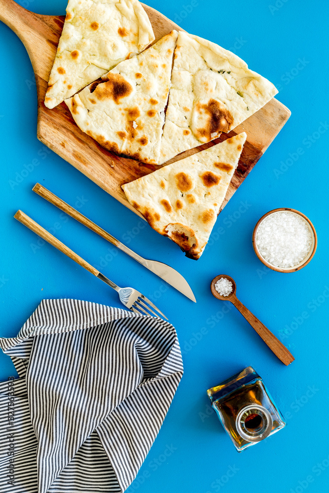 制作focaccia。传统的意大利面包，油从上到下放在蓝色桌子上