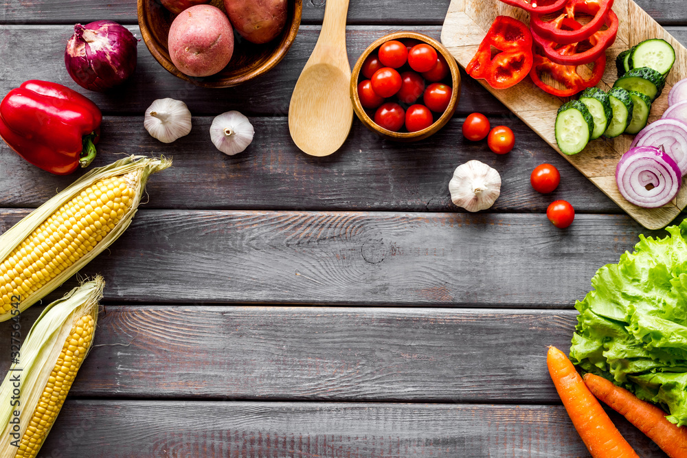 Autumn harvest. Vegetables - potato,cucumber, corn, greenery - frame on dark wooden background top-d