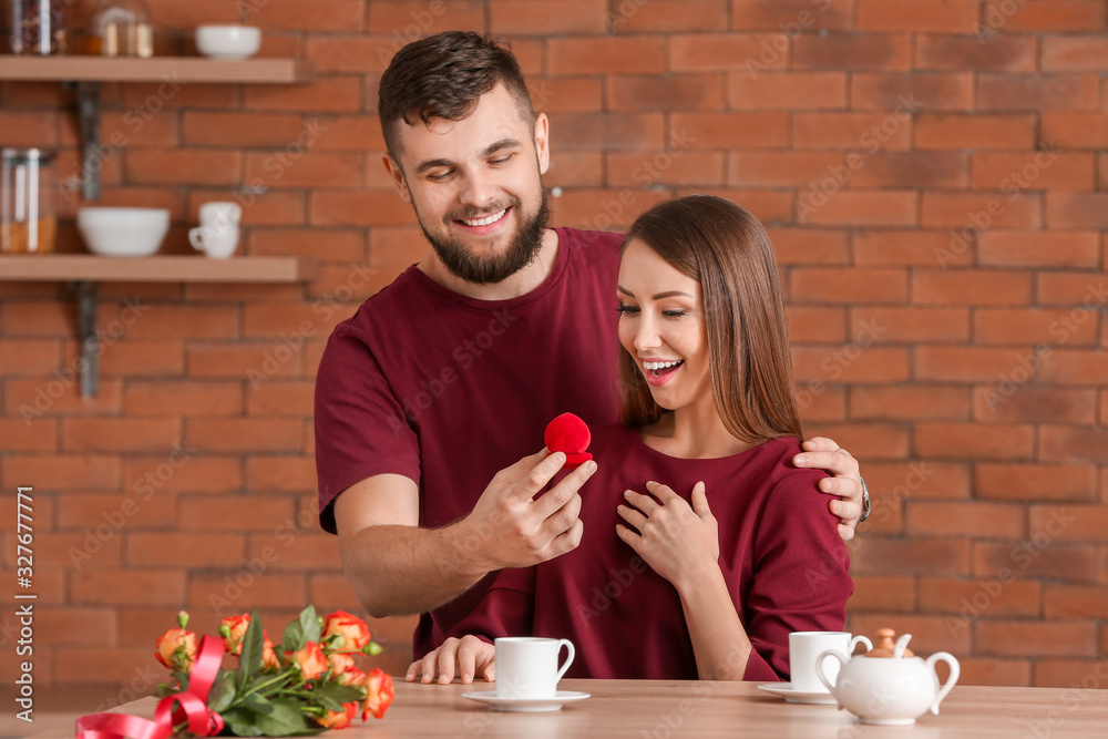 Young man proposing to his beloved at home