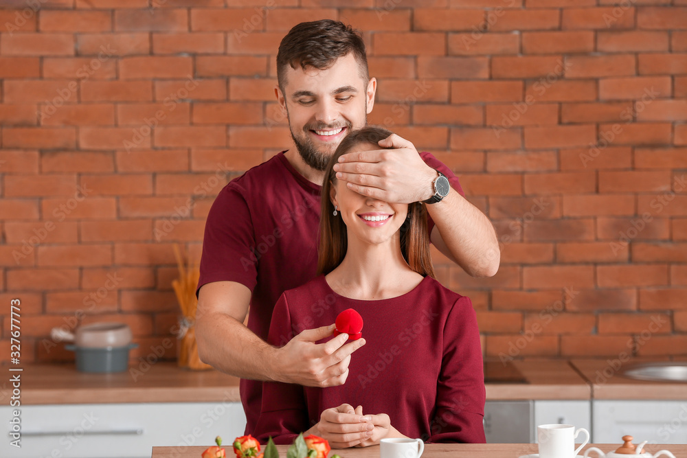 Young man proposing to his beloved at home