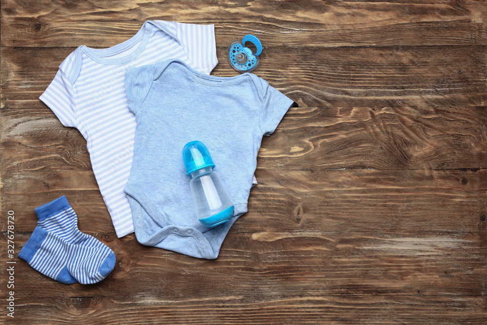 Baby clothes and accessories on wooden background