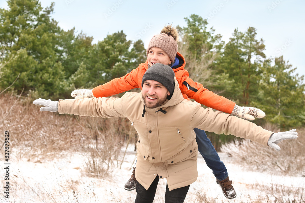 Father with little son in park on winter day