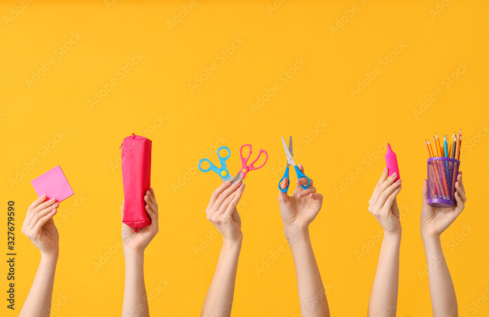 Many hands with school supplies on color background