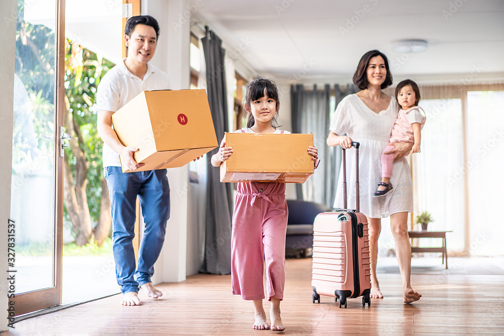 Asian big family moving packing boxes and cloth baggage to new house. Mother holding little cute bab