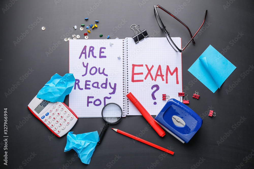 Stationery and notebook with text ARE YOU READY FOR EXAM? on dark background