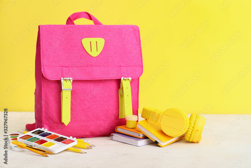 School backpack and stationery on table