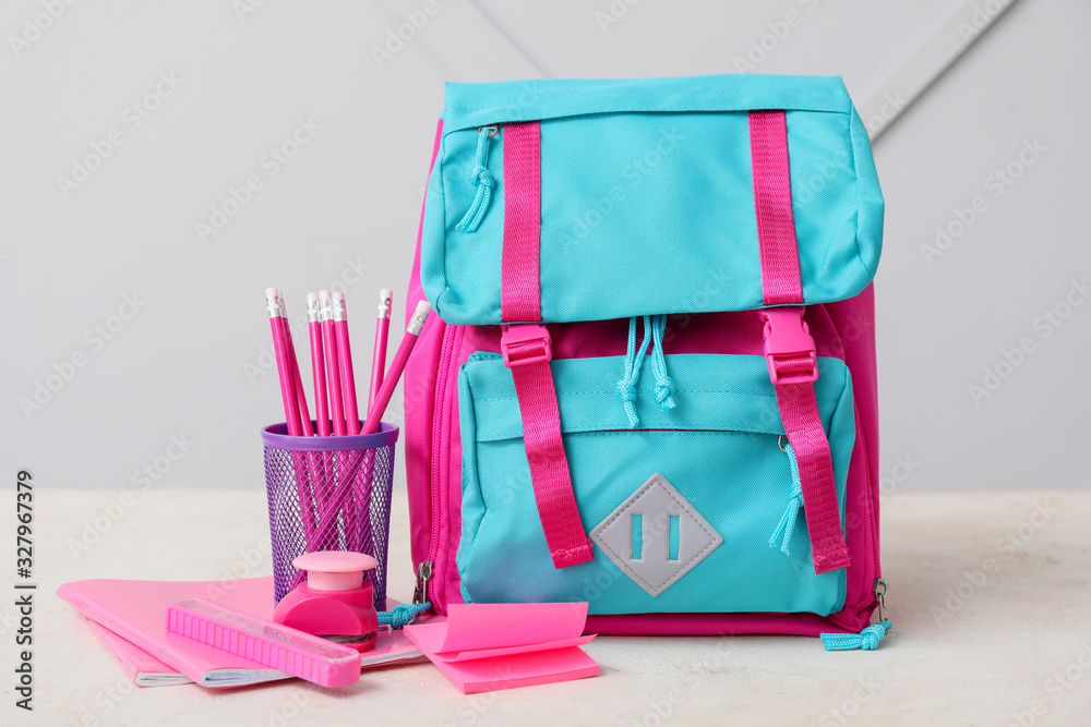 School backpack and stationery on table