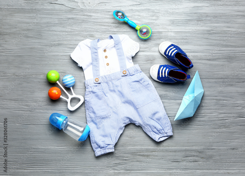 Baby clothes and accessories on wooden background