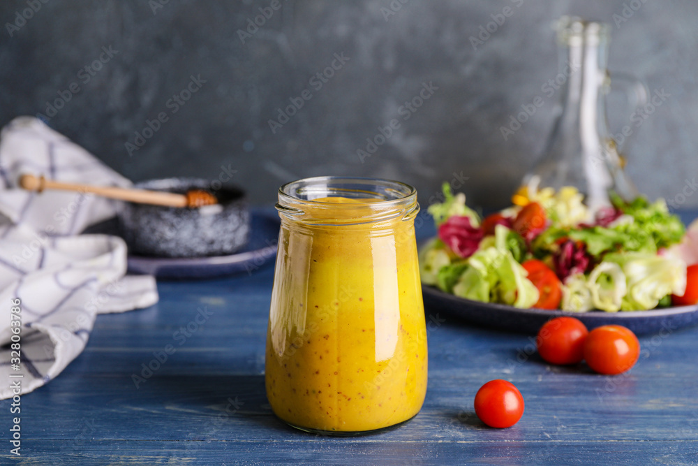 Jar of tasty honey mustard sauce on wooden table