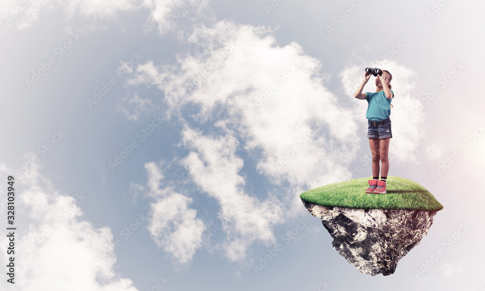 Concept of careless happy childhood with girl looking in binoculars