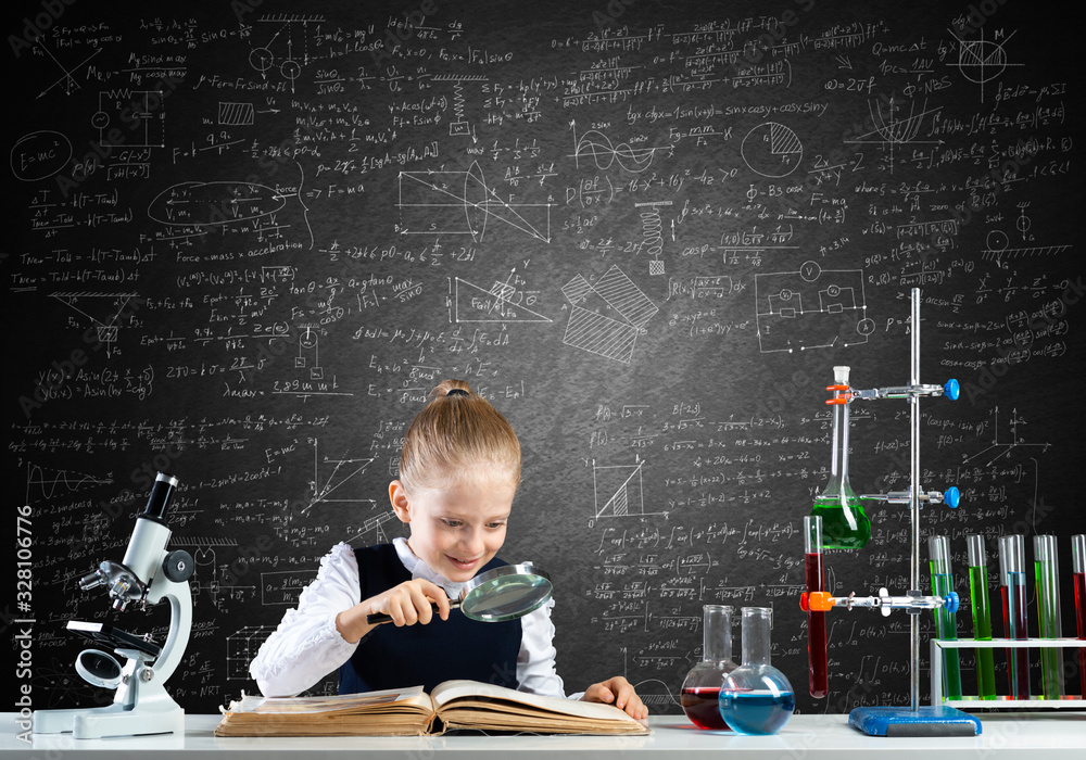 Little girl sitting at desk with magnifier