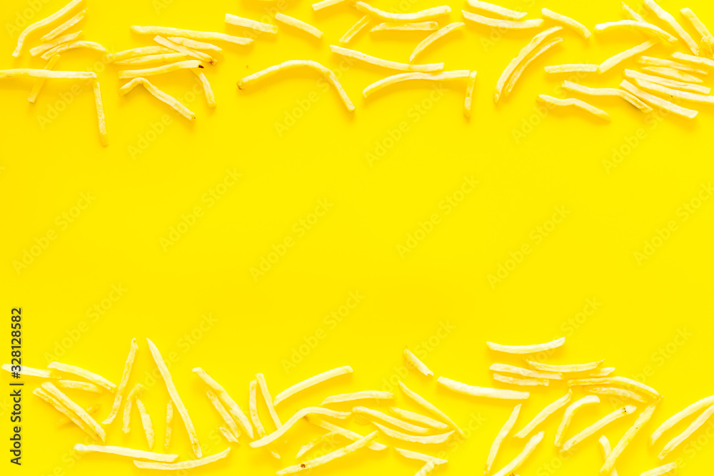 French fries frame on yellow table top-down copy space