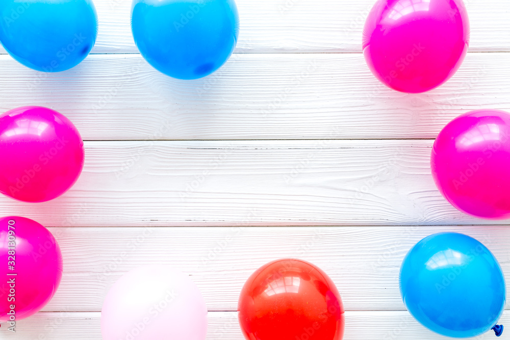 Decorative frame with colorful balloons on white wooden background top-down frame copy space