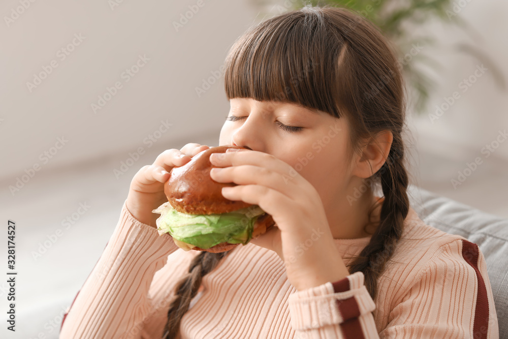 超重女孩在家吃不健康汉堡