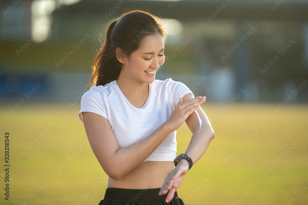 Woman runners apply sunscreen lotion before running.