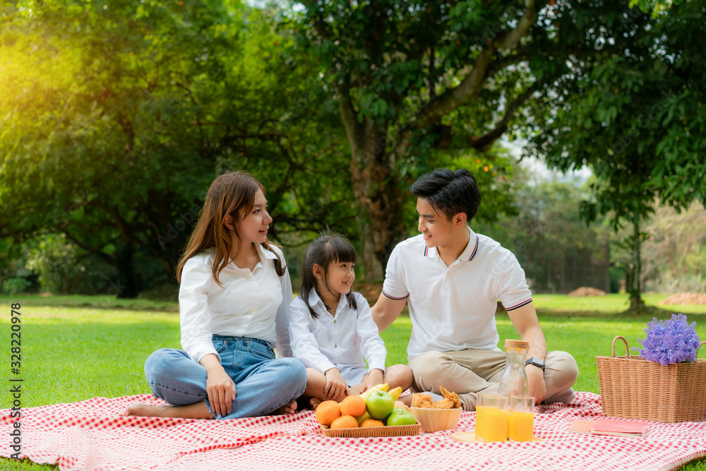 Asian teen family happy holiday picnic moment in the park with mother and daughter looking at father