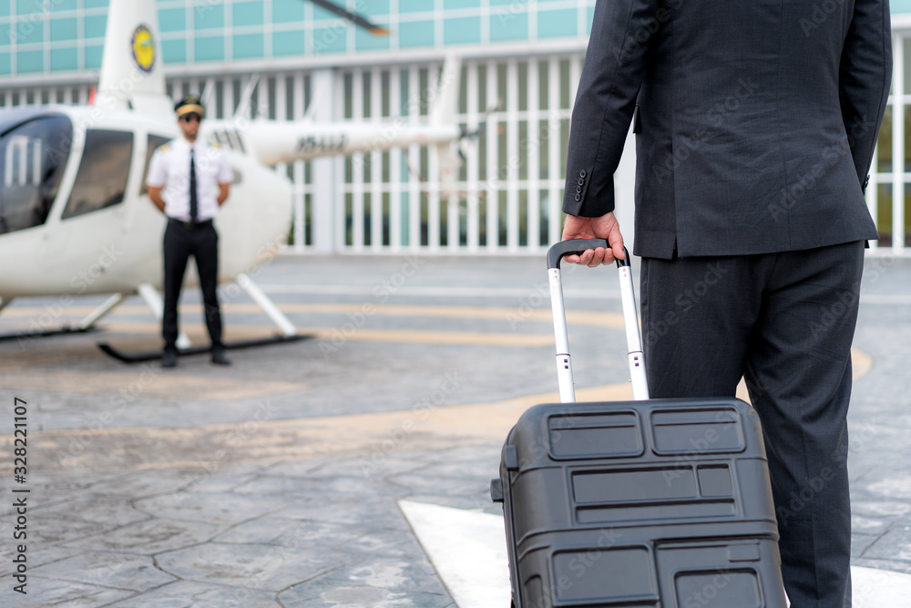 Executive Businessman manager with Luggage walking to helicopter to departure to destination at heli