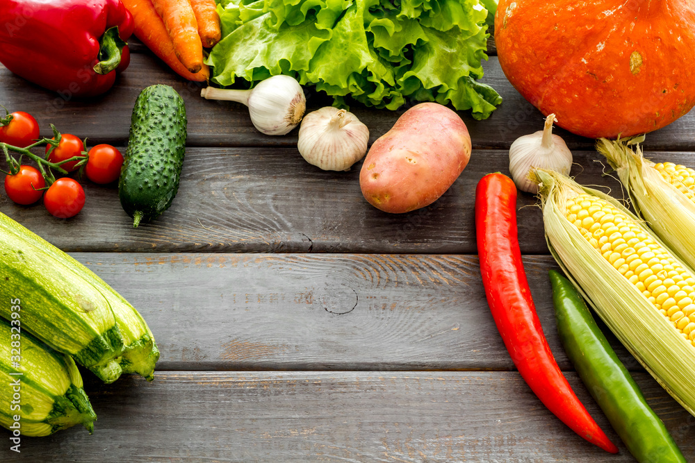 Set of autumn vegetables - potato, cucumber, carrot, greenery - on wooden background copy space