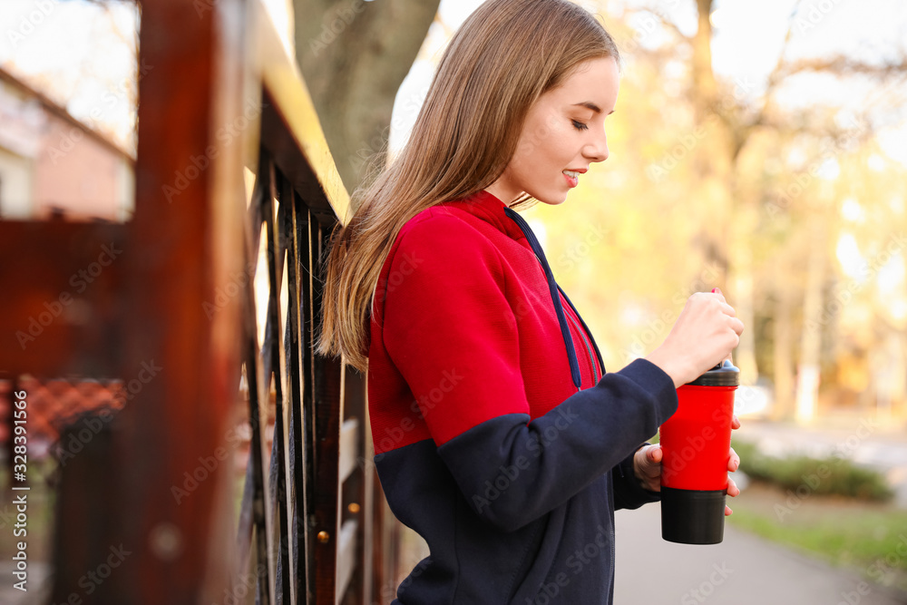 Young sporty woman with protein shake outdoors