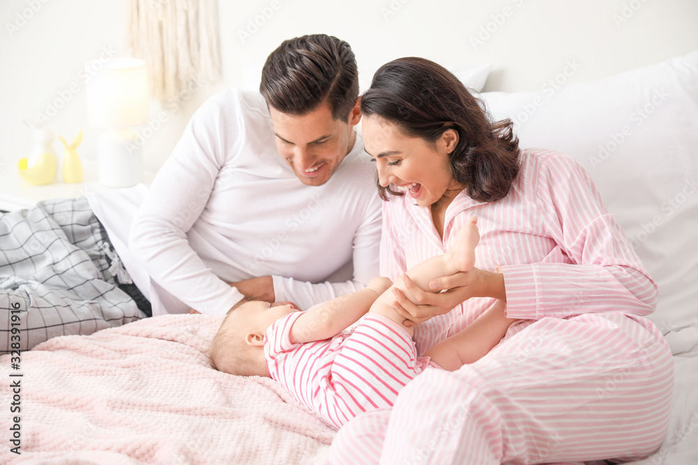 Cute baby with parents in bedroom