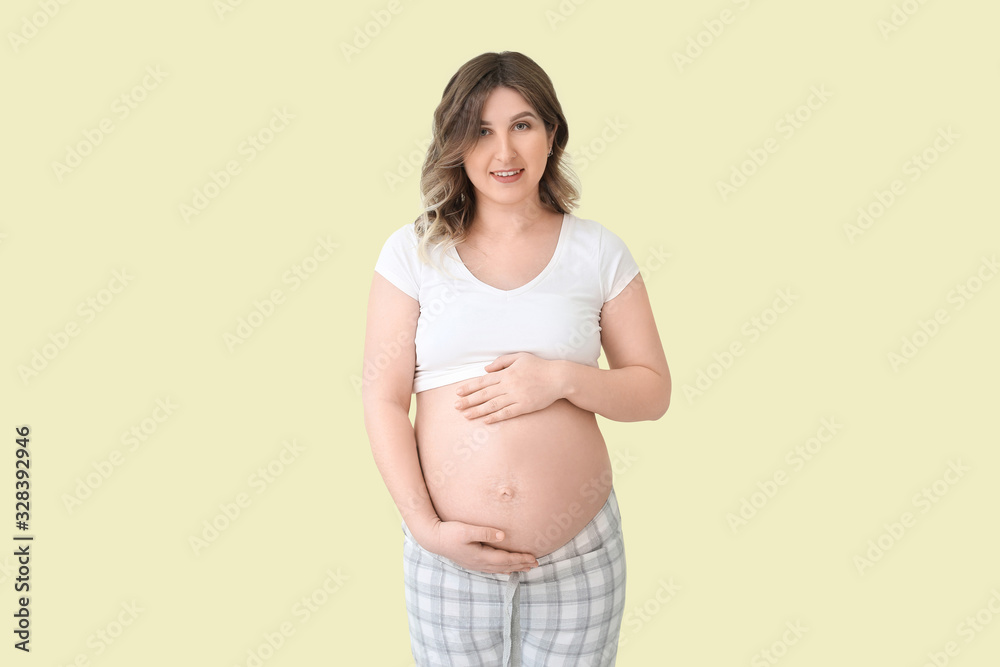 Beautiful pregnant woman on color background