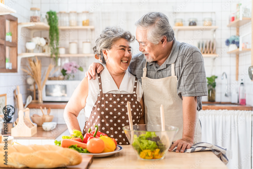 Couple senior Asian elder happy living in home kitchen. Grandfather cooking salad dish with grandmot