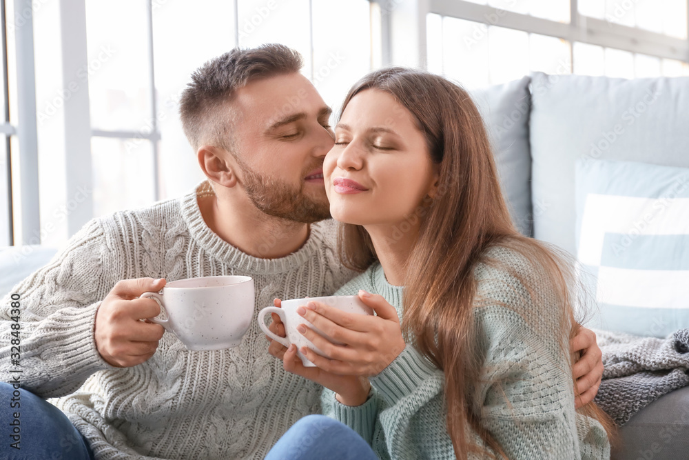 Happy young couple drinking coffee at home