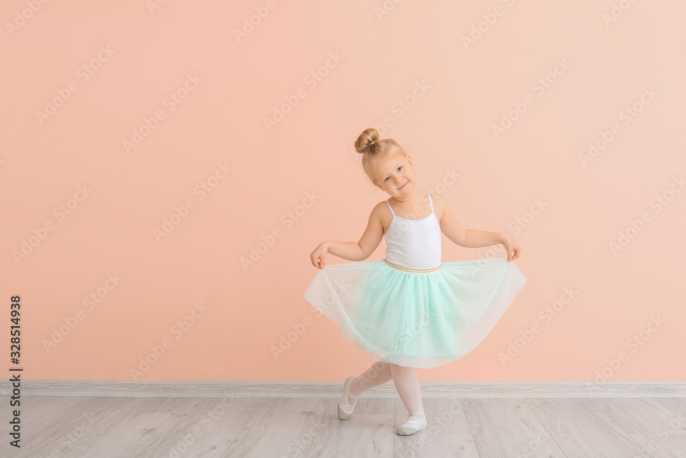 Cute little ballerina near color wall