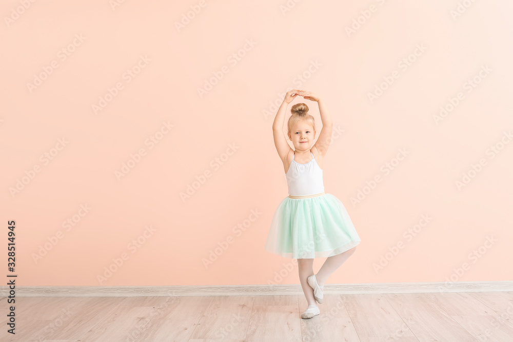 Cute little ballerina near color wall