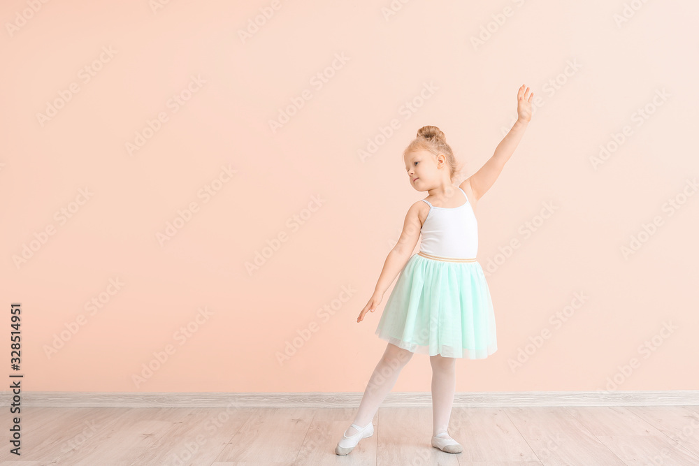 Cute little ballerina near color wall