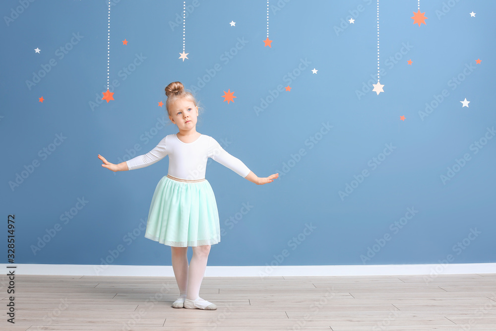 Cute little ballerina near color wall