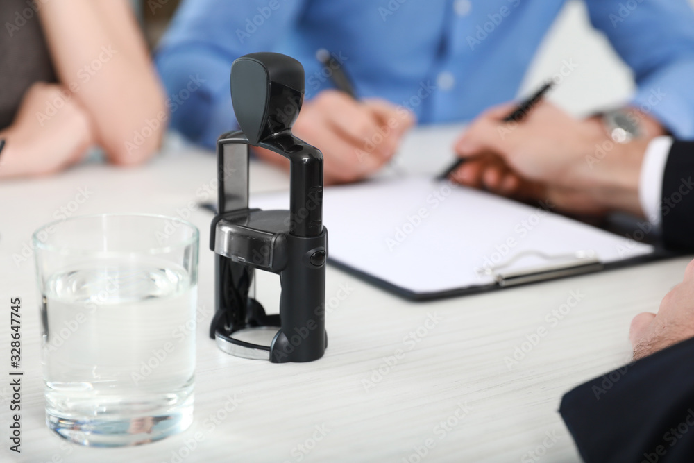 Glass of water with stamp on table of notary public in office