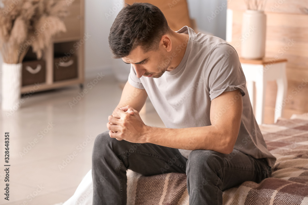 Depressed young man in bedroom